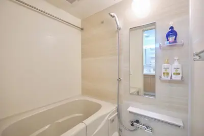 a bathroom with a tub and a shower with a mirror at J-ARC Akebonobashi by Tranova in Tokyo