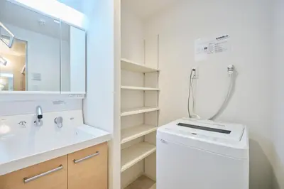 a bathroom with a sink and a washing machine at J-ARC Akebonobashi by Tranova in Tokyo