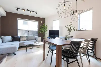 a living room with a couch and a table and chairs at Family Inn Hikifune in Tokyo