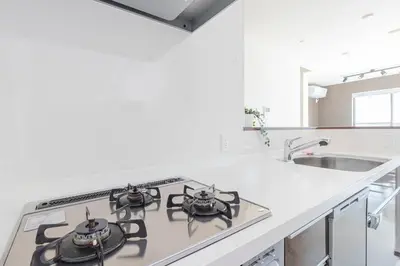 a white kitchen with a stove and a sink at Family Inn Hikifune in Tokyo