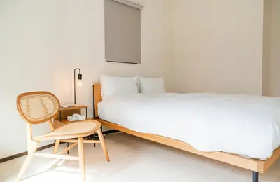 a bedroom with a large bed and a chair at Family Inn Hikifune in Tokyo