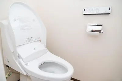 a bathroom with a white toilet with the lid up at Family Inn Hikifune in Tokyo