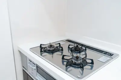 a kitchen stove top with four burners on it at Family Inn Hikifune in Tokyo