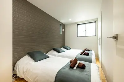 two beds in a small room with two brown towels at \u30c6\u30e9\u30b9\u5e73\u4e95 in Tokyo