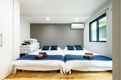 a bedroom with two beds and a window at \u30c6\u30e9\u30b9\u5e73\u4e95 in Tokyo