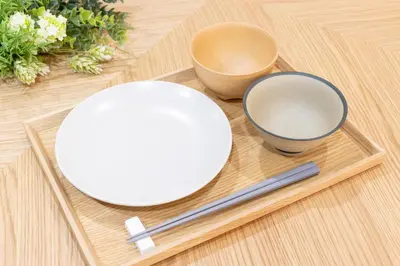 a plate and two bowls on a wooden table at Residence Stay Hanzomon - \u30ec\u30b8\u30c7\u30f3\u30b9\u30b9\u30c6\u30a3\u534a\u8535\u9580 in Tokyo