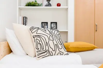 a bed with black and white pillows on it at Residence Stay Hanzomon - \u30ec\u30b8\u30c7\u30f3\u30b9\u30b9\u30c6\u30a3\u534a\u8535\u9580 in Tokyo