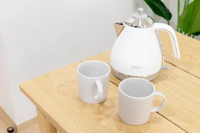 three white cups sitting on a table with a tea kettle at Residence Stay Hanzomon - \u30ec\u30b8\u30c7\u30f3\u30b9\u30b9\u30c6\u30a3\u534a\u8535\u9580 in Tokyo