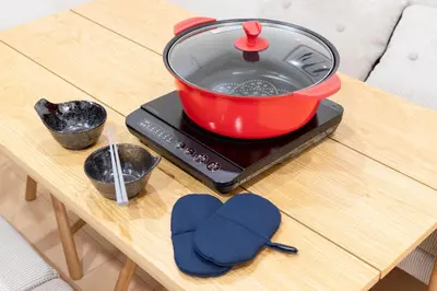 a red pot on top of a stove on a table at Residence Stay Hanzomon - \u30ec\u30b8\u30c7\u30f3\u30b9\u30b9\u30c6\u30a3\u534a\u8535\u9580 in Tokyo