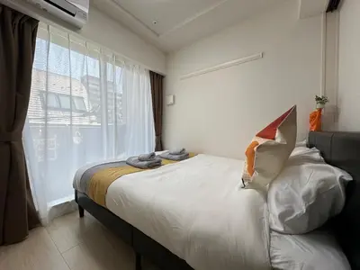 a bedroom with a bed with a large window at nestay inn tokyo ueno in Tokyo