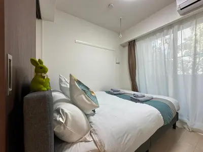 a bedroom with a bed with a stuffed rabbit sitting on it at nestay inn tokyo ueno in Tokyo