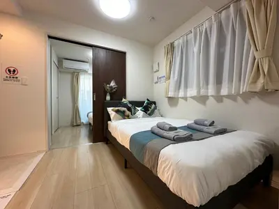 a bedroom with a large bed with towels on it at nestay inn tokyo ueno in Tokyo