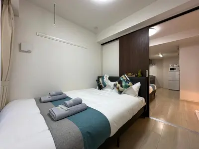 a bedroom with a large bed with two pillows on it at nestay inn tokyo ueno in Tokyo