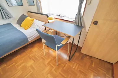 a bedroom with a bed and a desk and a bed and a table at TOMARIE Residential Suite Higashi-Tateishi in Tokyo