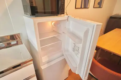 an open refrigerator with a microwave on top of it at TOMARIE Residential Suite Higashi-Tateishi in Tokyo