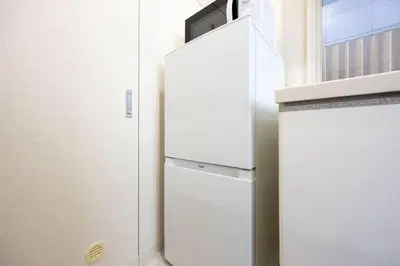 a white refrigerator in a kitchen next to a window at DeLCCS\u9ad8\u5186\u5bfa in Tokyo