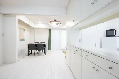 a white kitchen with a table and chairs at DeLCCS\u9ad8\u5186\u5bfa in Tokyo