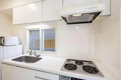 a white kitchen with a sink and a stove at DeLCCS\u9ad8\u5186\u5bfa in Tokyo