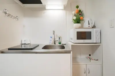 a kitchen with a sink and a microwave at \u4e00\u4e2a\u4eba\u65c5\u884c \u897f\u65b0\u5bbf\u7ad9\u6b65\u884c8\u5206 \u65b0\u5bbf\u7ad9\u5f92\u6b6516\u5206 JR\u5c71\u624b\u7ebf\u65b0\u5927\u4e45\u4fdd\u7ad9\u6b65\u884c15\u5206 \u514d\u8d39WiFi in Tokyo