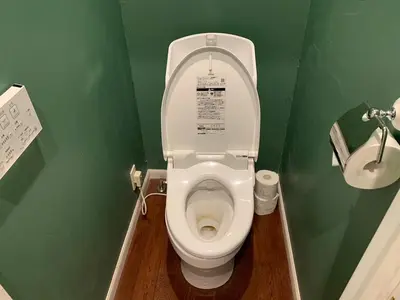 a bathroom with a white toilet in a green wall at \u30b6\u30b9\u30bf\u30f3\u30c0\u30fc\u30c9\u30a2\u30d1\u30fc\u30c8\u30e1\u30f3\u30c8\u6e0b\u8c37\u7b39\u585aRoom A in Tokyo
