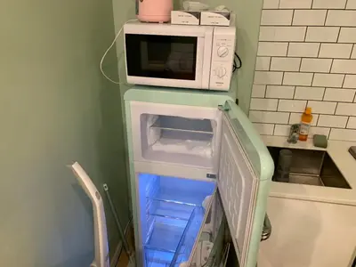 a microwave oven sitting on top of a refrigerator at \u30b6\u30b9\u30bf\u30f3\u30c0\u30fc\u30c9\u30a2\u30d1\u30fc\u30c8\u30e1\u30f3\u30c8\u6e0b\u8c37\u7b39\u585aRoom A in Tokyo