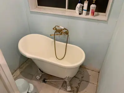 a white bath tub in a bathroom with a toilet at \u30b6\u30b9\u30bf\u30f3\u30c0\u30fc\u30c9\u30a2\u30d1\u30fc\u30c8\u30e1\u30f3\u30c8\u6e0b\u8c37\u7b39\u585aRoom A in Tokyo