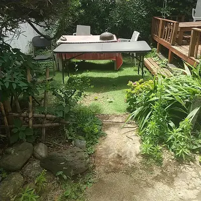 a table with a surfboard on it in a garden at \u30b6\u30b9\u30bf\u30f3\u30c0\u30fc\u30c9\u30a2\u30d1\u30fc\u30c8\u30e1\u30f3\u30c8\u6e0b\u8c37\u7b39\u585aRoom A in Tokyo