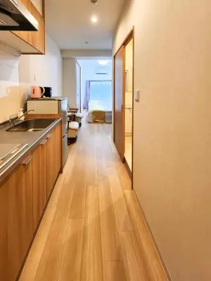 a kitchen with wooden floors and a long hallway at \u683c\u5b89\u6c11\u5bbf \u65e5\u66ae\u91cc\u99c5\u304b\u3089\u5f92\u6b694\u5206 \u9280\u5ea7 \u4e0a\u91ce\u76f4\u901a in Tokyo