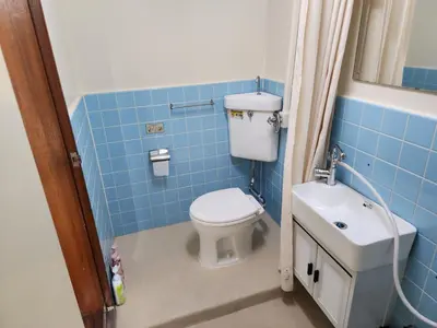 a blue tiled bathroom with a toilet and a sink at \u683c\u5b89\u6c11\u5bbf \u65e5\u66ae\u91cc\u99c5\u304b\u3089\u5f92\u6b694\u5206 \u9280\u5ea7 \u4e0a\u91ce\u76f4\u901a in Tokyo