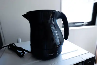 a black tea kettle sitting on top of a counter at shinjuku, tokyo city hall, apartment, Hotel for Max 6 person in Tokyo