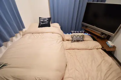 a living room with a large couch with a flat screen tv at Shinozaki Kodate - Vacation STAY 16392 in Tokyo