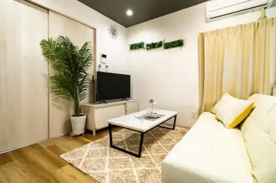 a living room with a white couch and a tv at 58, Higashi-Horikiri 2, private house rental, \u6771\u5800\u52072 in Tokyo