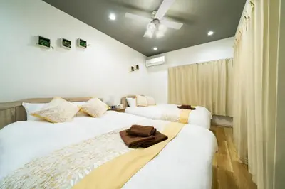 two beds in a room with white walls at 58, Higashi-Horikiri 2, private house rental, \u6771\u5800\u52072 in Tokyo