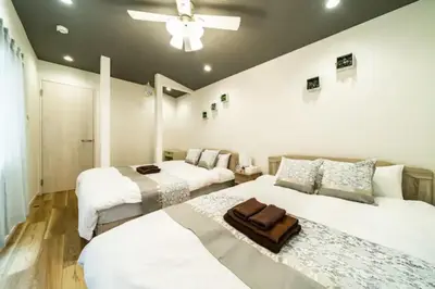 a bedroom with two beds and a ceiling fan at 58, Higashi-Horikiri 2, private house rental, \u6771\u5800\u52072 in Tokyo