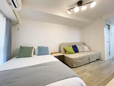 a bedroom with two beds and a couch at The Lions in Tokyo