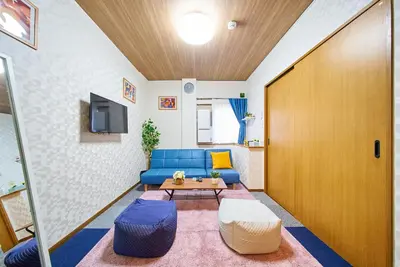 a living room with a blue couch and a table at Shinjuku 102 Private Stay Near Park and Station with Free WiFi in Tokyo