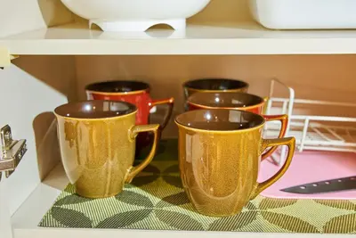 four gold cups on a shelf in a microwave at Shinjuku 102 Private Stay Near Park and Station with Free WiFi in Tokyo