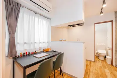 a room with a table and chairs and a toilet at Zaito Tokyo East Mukojima APT in Tokyo