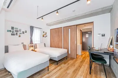 a bedroom with two beds and a desk and a desk at Zaito Tokyo East Mukojima APT in Tokyo