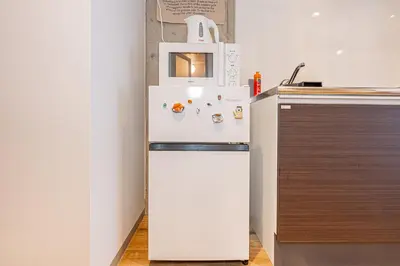 a white refrigerator with a microwave on top of it at Zaito Tokyo East Mukojima APT in Tokyo