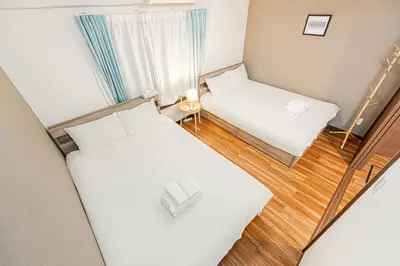a view of a room with two beds and a mirror at self-check in-\u5927\u585a\u99c5One minute in Tokyo