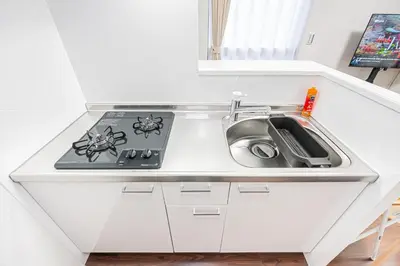 a kitchen counter with a sink and a stove at ZAITO Tokyo PRETIC Hikifune in Tokyo