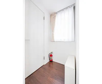 a living room with a red fire hydrant in the corner of a room at ZAITO Tokyo PRETIC Hikifune in Tokyo