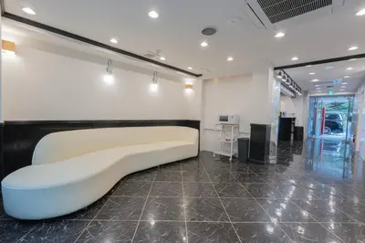 a white couch in a room with a wall at HOTEL TOKYO JOURNEY PORTAL KINSHICHO I Self Check-in Check-out Minutes from Sumiyoshi Station & Iconic Attractions & Sky Tree in Tokyo