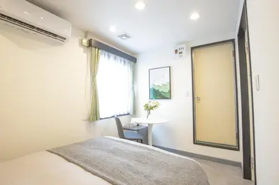 a bedroom with a bed and a table and a window at HOTEL TOKYO JOURNEY PORTAL KINSHICHO I Self Check-in Check-out Minutes from Sumiyoshi Station & Iconic Attractions & Sky Tree in Tokyo