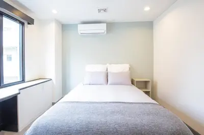 a bedroom with a bed with white walls and a window at HOTEL TOKYO JOURNEY PORTAL KINSHICHO I Self Check-in Check-out Minutes from Sumiyoshi Station & Iconic Attractions & Sky Tree in Tokyo
