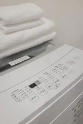 a remote control with towels on top of a washing machine at self-check in-\u62bc\u4e0a Tokyo Skytree in Tokyo