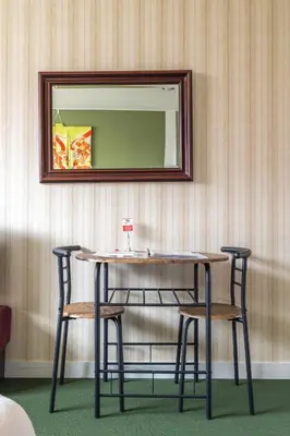 a table with two chairs and a mirror on a wall at The Ivy Apartments, BEST Location, Yoyogi!! in Tokyo