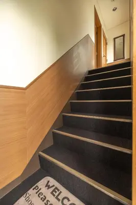 a set of stairs in a building with a welcome mat at The Ivy Apartments, BEST Location, Yoyogi!! in Tokyo