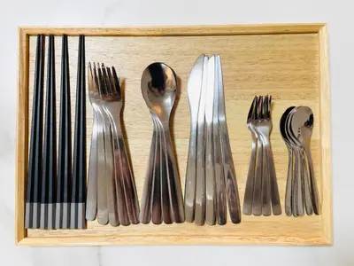 a wooden tray with silver forks and spoons at chano-ma in Tokyo